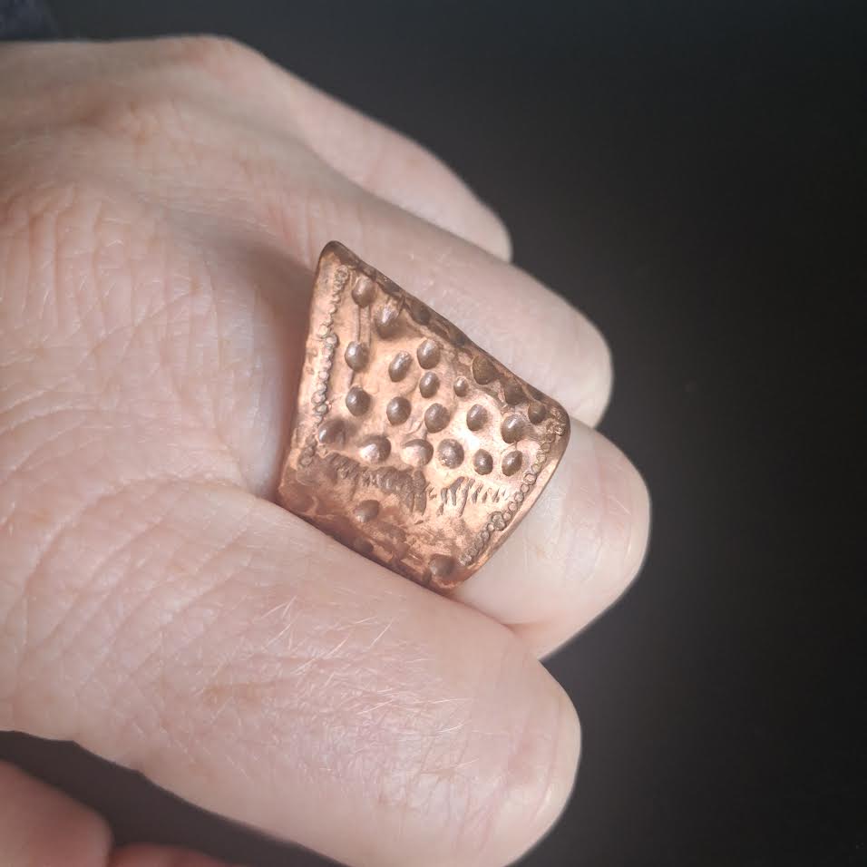 Heavily textured copper ring with architectural spine